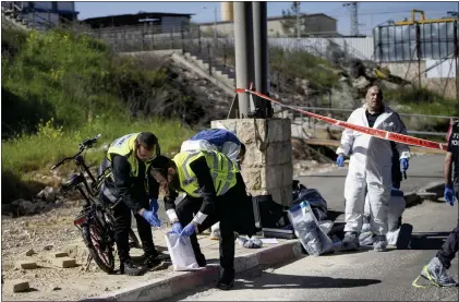  ?? MAHMOUD ILLEAN - THE ASSOCIATED PRESS ?? Israeli security forces inspect the scene of a stabbing attack at a checkpoint between Jerusalem and the West Bank on Wednesday. A Palestinia­n stabbed and wounded two people before being shot and killed.