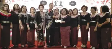  ??  ?? Dr Penguang (sixth left) presents the MRP grant cheque to SIDS Miri to Loretta witnessed by Monica (on Dr Penguang’s left) and the executive committee members.