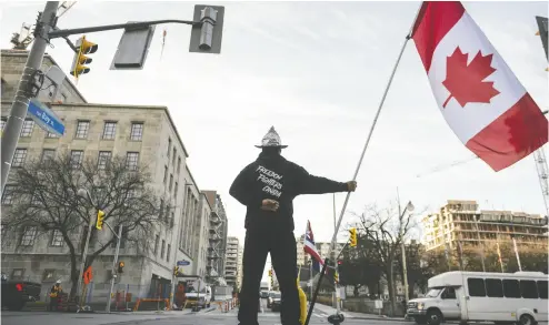  ?? JUSTIN TANG / THE CANADIAN PRESS FILES ?? A Freedom Convoy supporter stands in front of the Library and Archives Canada building in Ottawa, the site of the Public Order Emergency Commission, on Nov. 2. The inquiry’s hearings are scheduled to conclude on Friday.