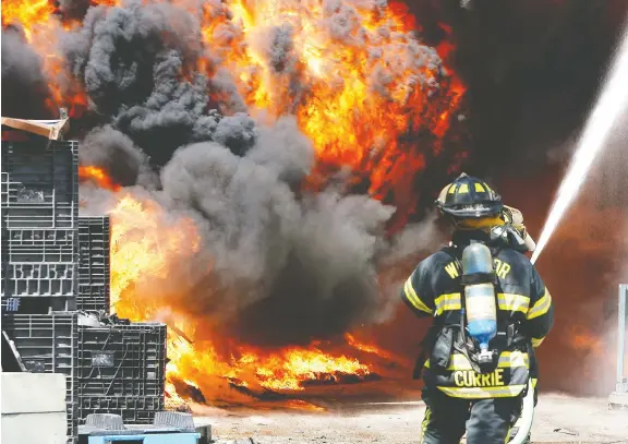  ?? SUPPLIED ?? Firefighte­r Wayne Currie, shown battling a blaze, says the job comes with many risks and health hazards. `We fight to ensure protection­s are in place,' he says.