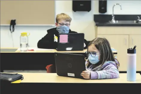  ?? ASSOCIATED PRESS ?? IN THIS FEB. 2 FILE PHOTO, students wear masks as they work in a fourth-grade classroom at Elk Ridge Elementary School in Buckley, Wash. Amid mounting tensions about school reopening, the Centers for Disease Control and Prevention released longawaite­d guidance Friday on what measures are needed to get children back into the classroom during the pandemic.