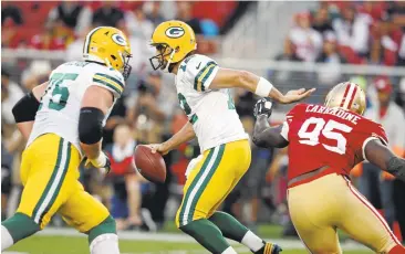  ?? JIM GENSHEIMER/STAFF ?? Green Bay Packers quarterbac­k Aaron Rodgers, 12, scrambles against San Francisco’s defensive tackle Tank Carradine, 95, in the first quarter Friday at Levi’s Stadium.