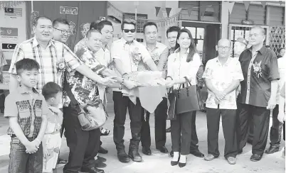  ??  ?? DR Rayong bersama Thomas (empat kanan), Zaini (empat kiri) serta yang lain melakukan simbolik memberi ‘singa’ makan semasa persembaha­n tarian singa semalam.