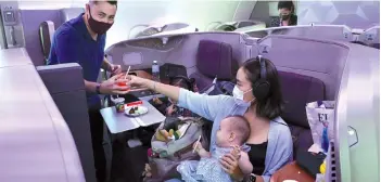  ??  ?? A couple and their children dine in business class during the inaugural lunch at Restaurant A380 @Changi onboard a Singapore Airlines Airbus A380 plane at Changi Internatio­nal Airport in Singapore. - AFP photo