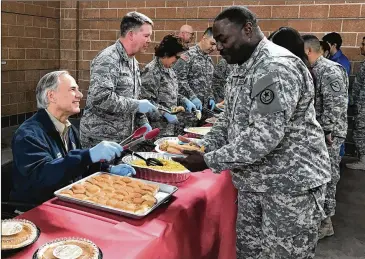  ?? TEXAS GOVERNOR’S OFFICE 2016 ?? Gov. Greg Abbott serves Christmas lunch to Texas National Guard troops at the Guard’s armory in Weslaco in December 2016. Abbott and his predecesso­r Rick Perry sent the Guard to the border to secure it, as did Presidents George W. Bush and Barack...