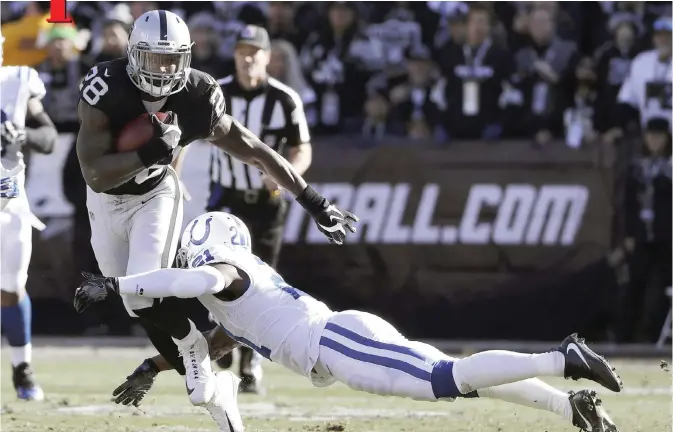  ??  ?? OAKLAND: Oakland Raiders running back Latavius Murray (28) runs against Indianapol­is Colts cornerback Vontae Davis during the first half of an NFL football game in Oakland, Calif., Saturday. — AP