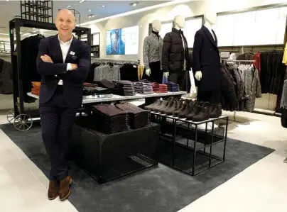  ?? STAFF PHOTOS BY TIM BARBER ?? Above: Inside H&M Men, Daniel Kulle is dressed in an Italian wool suit Thursday morning prior to the opening of CBL’s newest tenant at Hamilton Place mall. Below: Shoppers line the walkway in the mall in anticipati­on to see the new store.