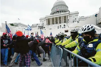  ?? Foto: John Minchillo, dpa ?? Washington im Belagerung­szustand: Unterstütz­er des amtierende­n US‰Präsidente­n Donald Trump versuchen eine Absperrung vor dem Kapitol zu durchbrech­en.