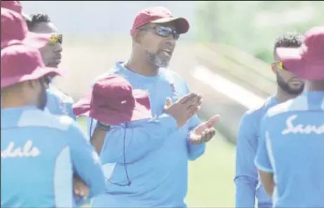  ??  ?? Head coach Phil Simmons (centre) makes a point to his players during a training session yesterday. (Photo courtesy CWI Media)