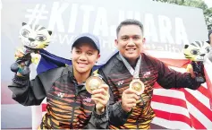  ?? — BERNAMA photo ?? National archers Fatin Nurfatehah Mat Salleh (left) and Mohd Juwaidi Mazuki celebrate after winning and retaining the mixed team Compound title.