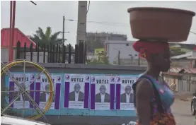  ?? Photo: Nampa/AFP ?? Poll fever… A woman walks past Ivory Coast’s presidenti­al candidate Kouadio Konan Bertin campaign posters in a street in Abidjan.