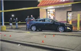  ??  ?? Shell casings are marked as police investigat­e a shooting later Sunday at a Popeyes restaurant at Chicago and Kedzie.