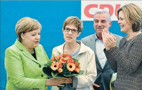  ?? JOHN MACDOUGALL / AFP ?? Angela Merkel entregando un ramo de flores a la presidenta reelecta de Sarre, Annegret Kramp-Karrenbaue­r, ayer en Berlín