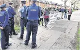  ?? PHOTO: STEVE HUMPHREYS ?? Target: Gardaí and protesters at Richard Bruton’s home in north Dublin.