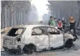  ?? ARMANDO FRANCA, AP ?? Police investigat­ors examine a burned car in Portugal, where hundreds of soldiers and firefighte­rs battled runaway flames.