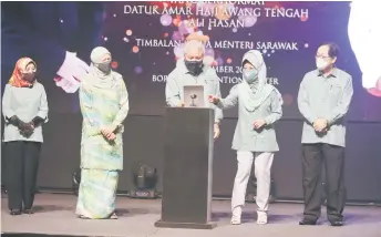  ?? — Photo by Chimon Upon ?? Awang Tengah (centre) presses a button to launch the event as Fatimah (second right) and others look on.