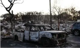  ?? Photograph: Yuki Iwamura/AFP/Getty Images ?? A burnt out car lies in the driveway of charred apartment complex in the aftermath of a wildfire in Lahaina, western Maui, on Saturday.