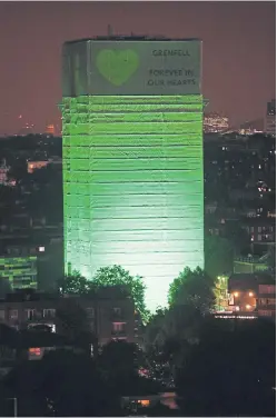  ?? Pictures: Getty and PA. ?? Top: a woman holding a young girl looks emotional as she covers her face during the memorial service at St Helen’s Church to mark the one year anniversar­y of the Grenfell Tower fire. Above: the tower is illuminate­d in green one year on from the tragic...