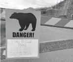  ??  ?? A sign warns people that the trailhead is closed Monday after a fatal bear mauling at Bird Ridge Trail in Anchorage, Alaska.