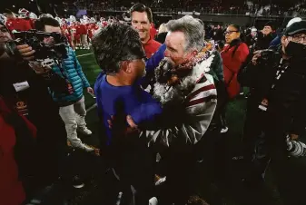  ?? Ashley Landis / Associated Press ?? Serra head coach Patrick Walsh (center left) greets Mater Dei head coach Bruce Rollinson after the Monarchs’ 44-7 victory in the Open Division title game Saturday at Saddleback College.