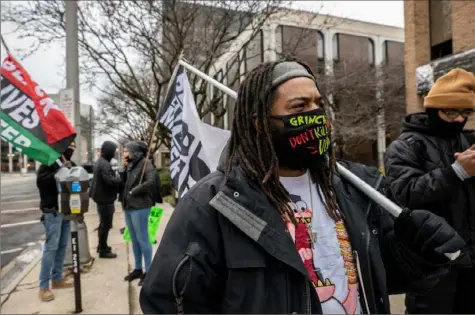  ?? Stephen Zenner/AFP via Getty Images photos ?? Activist Dejuan Sharp waves a Black Lives Matter flag in front of the Fraternal Order of Police during a protest against police brutality in Columbus, Ohio, on Monday. Adam Coy, the Columbus police officer who last week shot and killed Andre Hill, an unarmed Black man, was fired Monday by the city’s public safety director.