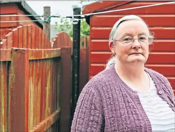  ?? Picture Andrew Cawley ?? Helen Dillet next to the disputed fence in the garden of her lifelong home in Fauldhouse