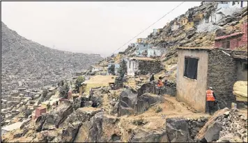  ?? FAHIM ABED / THE NEW YORK TIMES ?? Painters begin to add color to a home on a hillside in Kabul, Afghanista­n, in an attempt by the municipali­ty to make the sprawl look nicer. The city, one of the fastest growing in the world, has already expanded to more than five times its intended size.