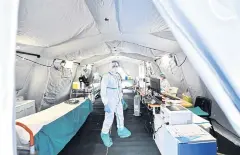  ??  ?? FULLY SUITED UP: Medical personnel wearing protective face masks are seen inside the Spedali Civili hospital in Brescia, Italy.