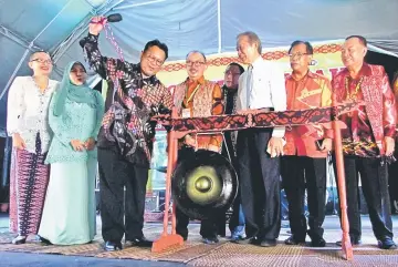  ??  ?? Nanta strikes the gong to officiate at the opening of BCF 2017’s Borneo Dayak Cultural Festival Pavilion, witnessed by Tiong (third right), Rogayah (second left) and other VIPs.