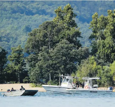  ?? CHARLIE RIEDEL/THE ASSOCIATED PRESS ?? Emergency workers patrol an area Friday near where a duck boat capsized the night before. Authoritie­s say the small boat sank to the bottom of Table Rock Lake in Branson, Mo., killing 17 people and injuring seven.