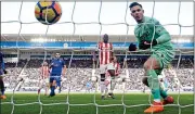  ??  ?? THROUGH BALL: Butland watches in horror after his slip-up