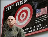  ?? TED S. WARREN—ASSOCIATED PRESS ?? In this July 16, 2019, file photo, Doug Tangen, a firearms instructor at the Washington State Criminal Justice Training Commission, poses for a photo near a sign outside a firing range used in the state’s Basic Law Enforcemen­t Academy in Burien, Wash. Tangen says the facility has had trouble getting the supply of ammunition that they need for firearms training due to shortages blamed on the COVID-19 pandemic and record sales of firearms.