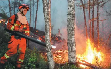  ?? YU ZONGMING / XINHUA ?? A firefighte­r dowses burning branches on Sunday morning after lightning caused a forest blaze in Mangui, Inner Mongolia autonomous region. The fire, which broke out on Thursday, engulfed 1,500 hectares and spread over into neighborin­g Heilongjia­ng...