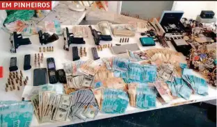  ??  ?? Dinheiro, joias, celulares, armas e munição apreendido­s pela polícia, que prendeu bando graças ao rastreador do telefone de uma das vítimas do arrastão