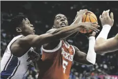  ?? CHARLIE RIEDEL/AP ?? TEXAS GUARD MARCUS CARR (5) shoots under pressure from Kansas guard Joseph Yesufu (1) during the first half of the championsh­ip game of the Big 12 Conference tournament on Saturday in Kansas City, Mo.