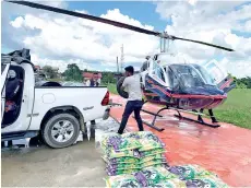  ??  ?? Packets of rice and other supplies go into the helicopter at Pitas town before they are flown to Kampung Lok Dangkaan also in Pitas.