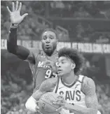  ??  ?? The Cavaliers' Kevin Porter Jr. drives past the Heat's Jae Crowder on Monday night in Cleveland.