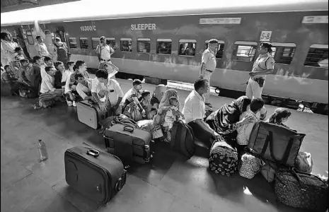  ?? SIDDHARAJ SOLANKI/HTPHOTO ?? Migrants from Uttar Pradesh and Bihar queue up at a railway station in Ahmedabad, Gujarat, on Tuesday.