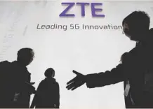  ?? — Reuters ?? Visitors pass in front of the ZTE booth at the Mobile World Congress in Barcelona, in this file photo.