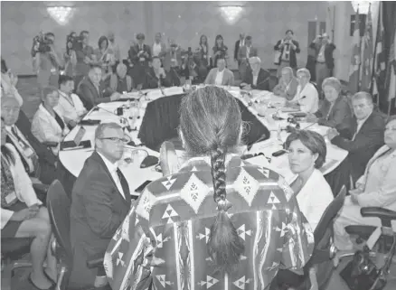  ?? Aaron Lynett/the Canadian Press ?? Elder Walter Cooke, centre, holds an eagle feather as he conducts the opening prayer for premiers from across the country and National Aboriginal Organizati­on leaders during a meeting in Niagara-on-the-Lake, Ont., Wednesday.