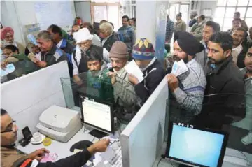  ??  ?? KASHMIR: Indians stand in a queue to deposit discontinu­ed notes in a bank in Samba dis- trict of Jammu and Kashmir.