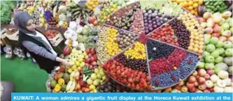  ?? — Photo by Yasser Al-Zayyat ?? KUWAIT: A woman admires a gigantic fruit display at the Horeca Kuwait exhibition at the Mishref fairground­s yesterday.