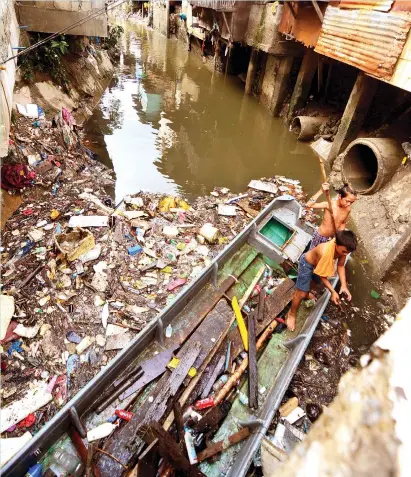  ?? SUNSTAR FILE ?? RISK AT THE MARGINS. Young boys scavenge for items they can use from the garbage floating in Mahiga Creek bordering Mandaue and Cebu cities. Out-of-school youth and the marginaliz­ed have a higher risk of initiating drug use, according to the United...