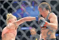  ?? MARK J. TERRILL/THE ASSOCIATED PRESS ?? Holly Holm, left, connects on a punch against Raquel Pennington during their UFC 184 bantamweig­ht bout Saturday at the Staples Center in Los Angeles. Holm won by split decision.