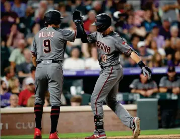  ?? ASSOCIATED PRESS ?? ARIZONA DIAMONDBAC­KS’ JOSH ROJAS (LEFT) celebrates with Nick Ahmed as he crosses home plate after Ahmed hit a two-run home run off Colorado Rockies relief pitcher Jake McGee in the sixth inning of Monday’s game in Denver.