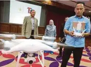  ?? PIC BY ROZAINAH ZAKARIA ?? Terengganu Economic Planning Unit officer Hafizul Izwan Md Razali demonstrat­ing the versatilit­y of a drone in Kuala Terengganu yesterday.