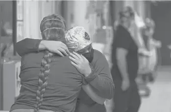  ?? GERALD HERBERT/AP ?? ICU nurse Melinda Hunt, facing, hugs the sister of a COVID-19 patient she had been caring for who had just died on Aug. 18 inside a COVID-19 unit at the Willis-knighton Medical Center in Shreveport, Louisiana.