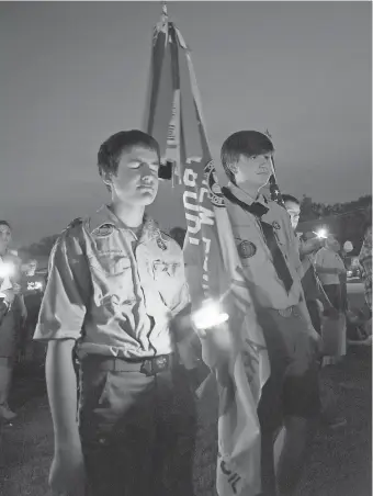  ?? LES HASSELL, THE NEWS- JOURNAL , VIA AP ?? Ian Sullens of Troop 621, left, and Samuel Powers of Troop 201 mourn at a candleligh­t vigil Sunday in Hallsville, Texas.