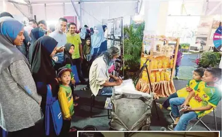  ?? BY AMRAN HAMID PIX ?? An artist drawing a portrait of two children at Ekspo Muafakat Kedah 2018 yesterday. (Inset) Visitors solving a puzzle at the expo.