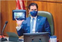  ?? EDDIE MOORE/JOURNAL ?? House Speaker Brian Egolf, D-Santa Fe, holds a tablet to show that House proceeding­s were still being streamed online during debate on a civil rights bill in the House on Tuesday.